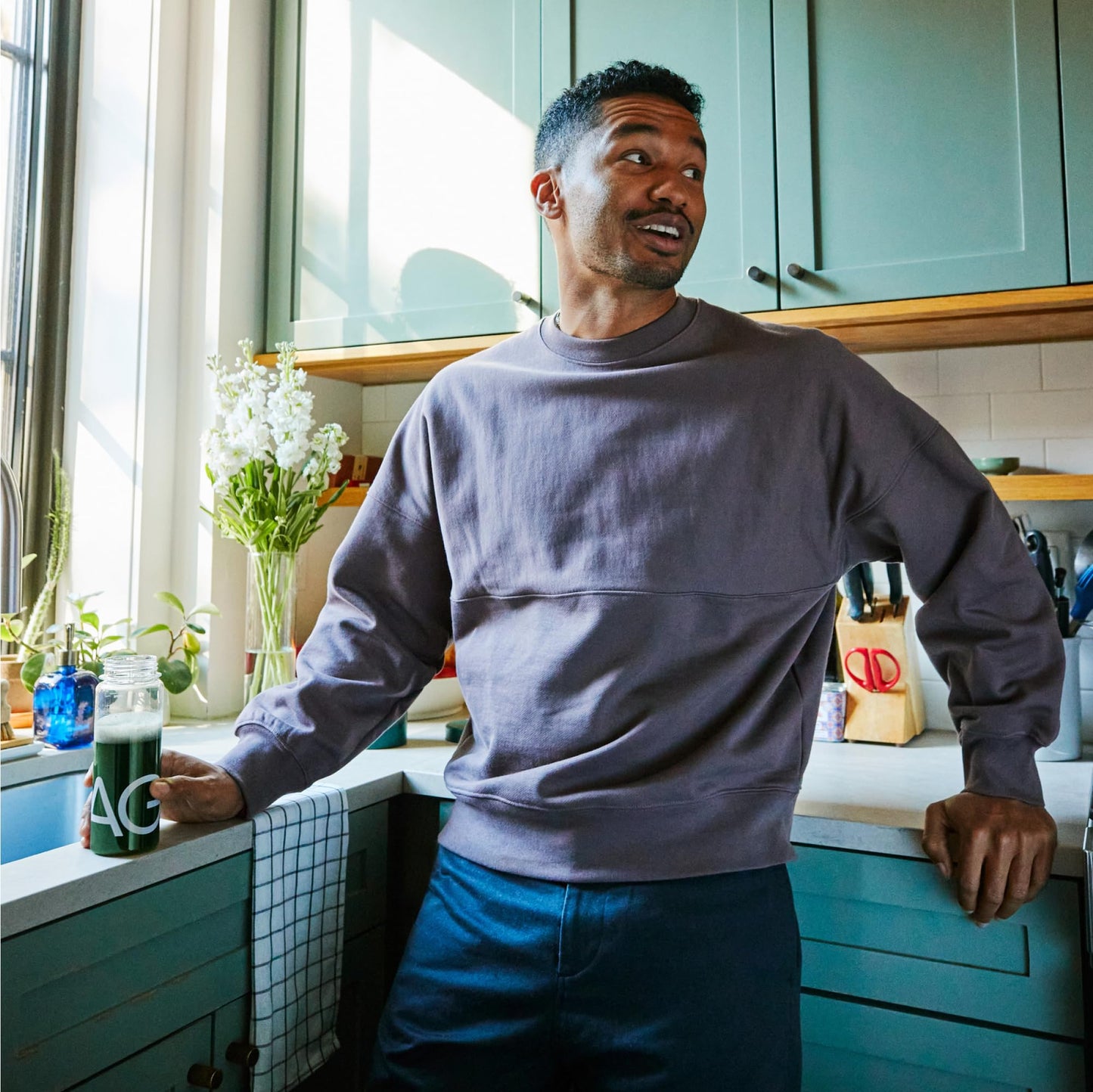 Hombre con bebida AG1 en la cocina