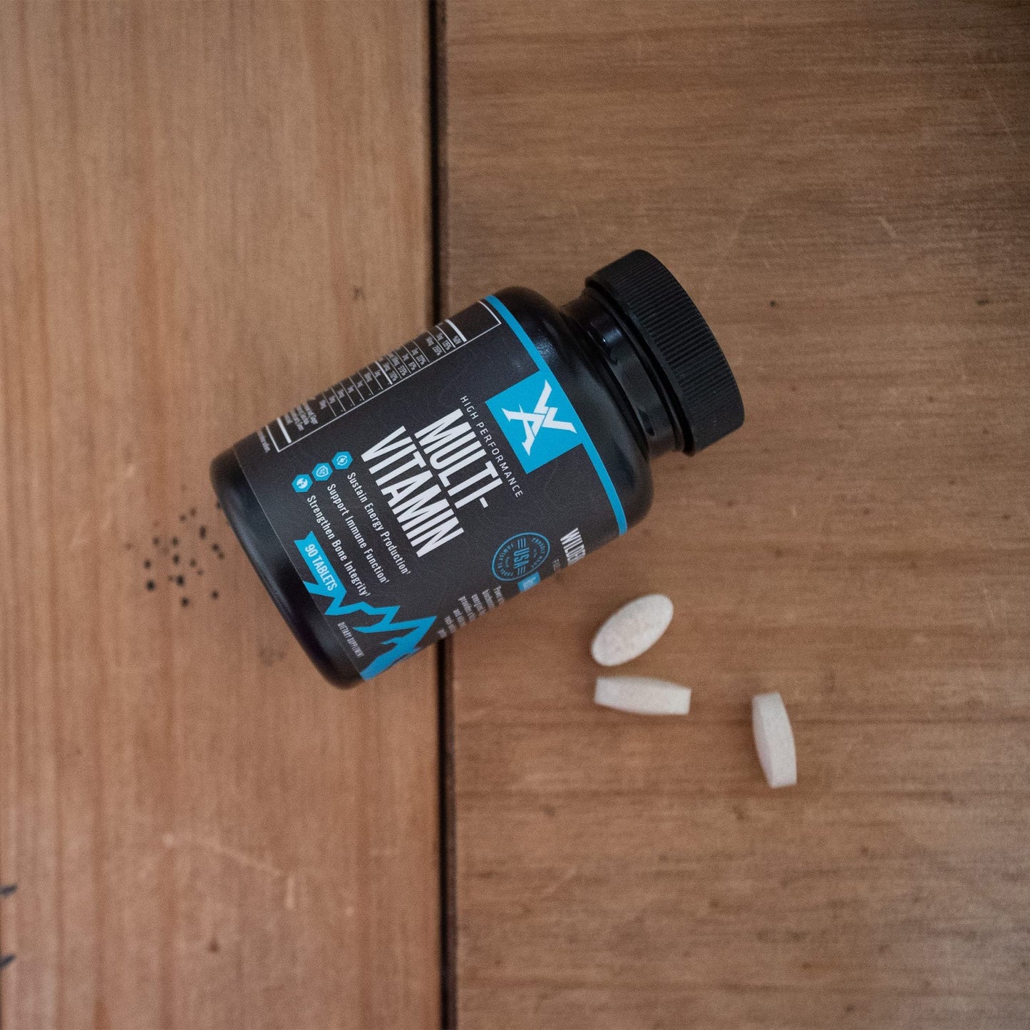 Multivitamínico Wilderness Athlete en mesa de madera