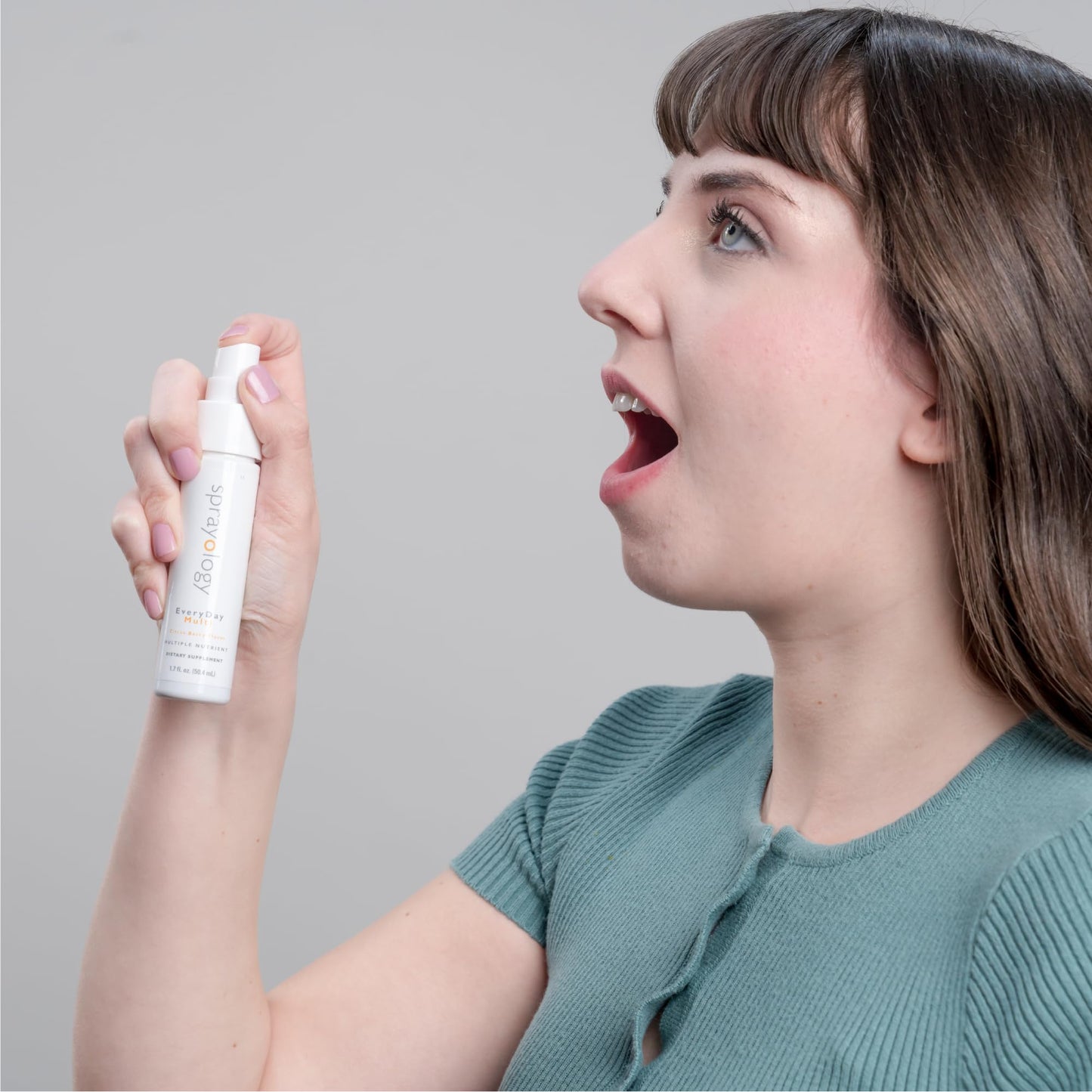 Persona utilizando spray multivitamínico en su boca