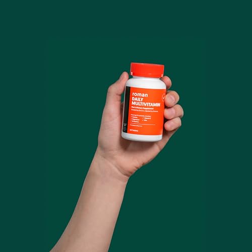 Tabletas de multivitaminas diarias ROMAN sostenidas en la mano.