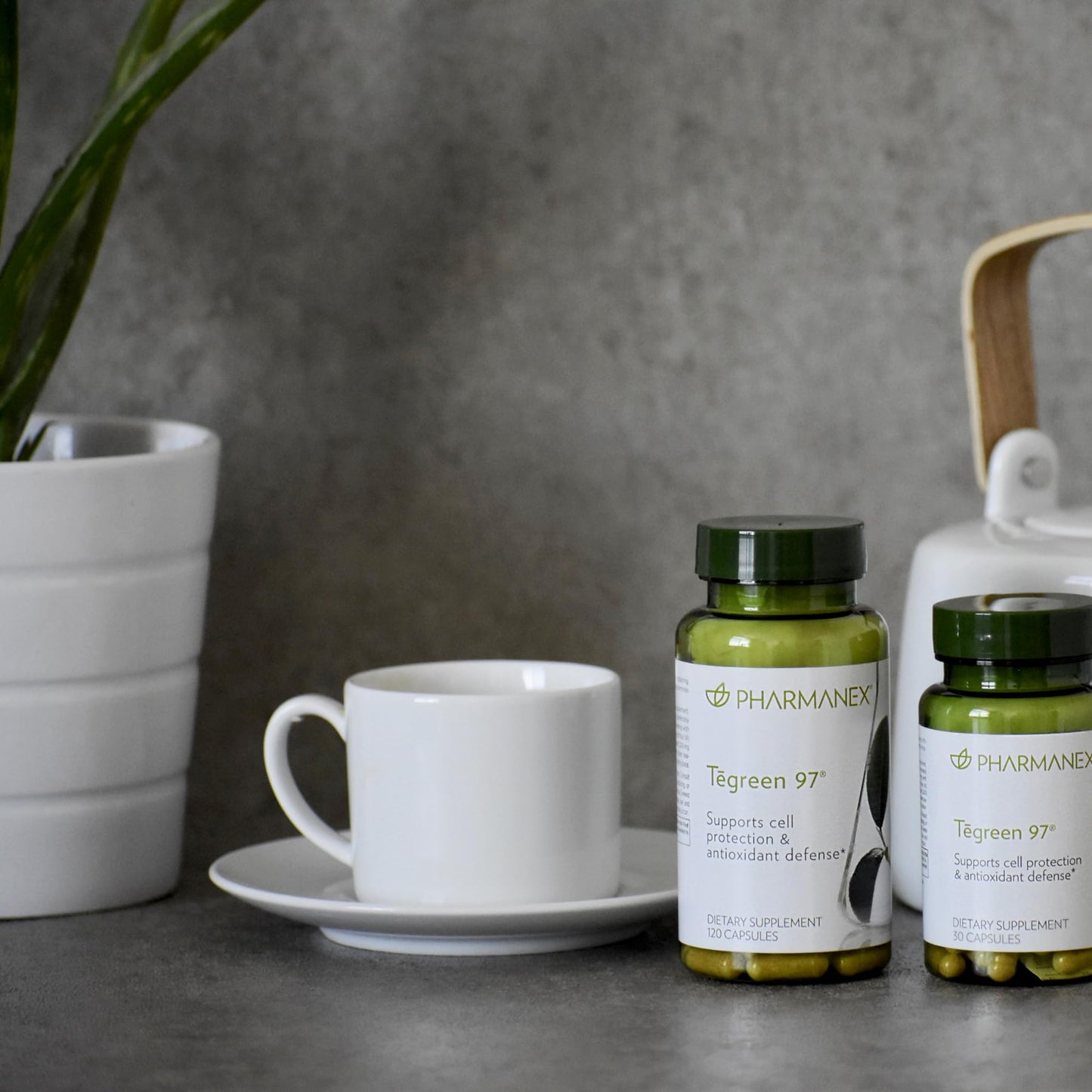 Tegreen 97 de Nu Skin en una mesa con taza y tetera