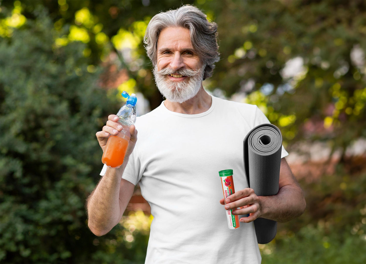 Hombre con bebida vitaminada y yoga mat en el jardín.