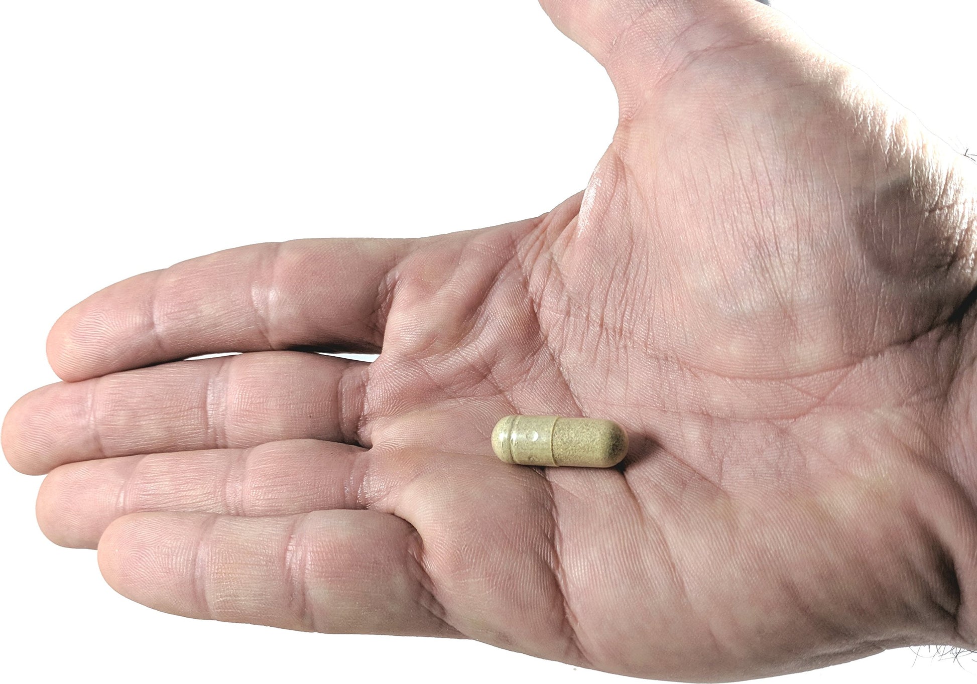 Cápsula de suplemento inmune sobre una mano.