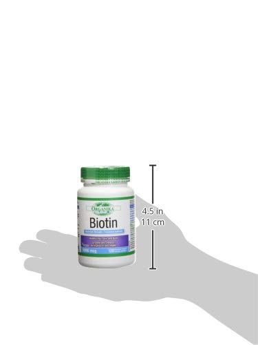 Comprimidos de biotina Organika en la mano.