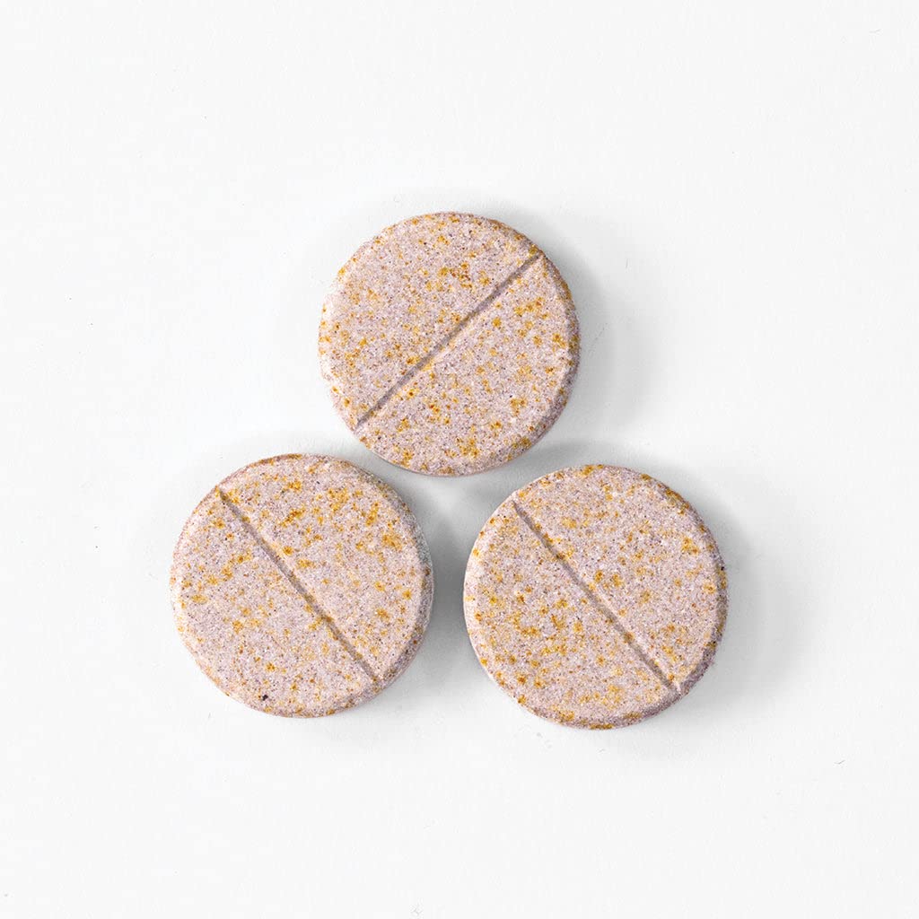 Envase de vitaminas Celebrate masticables con tabletas y uvas.