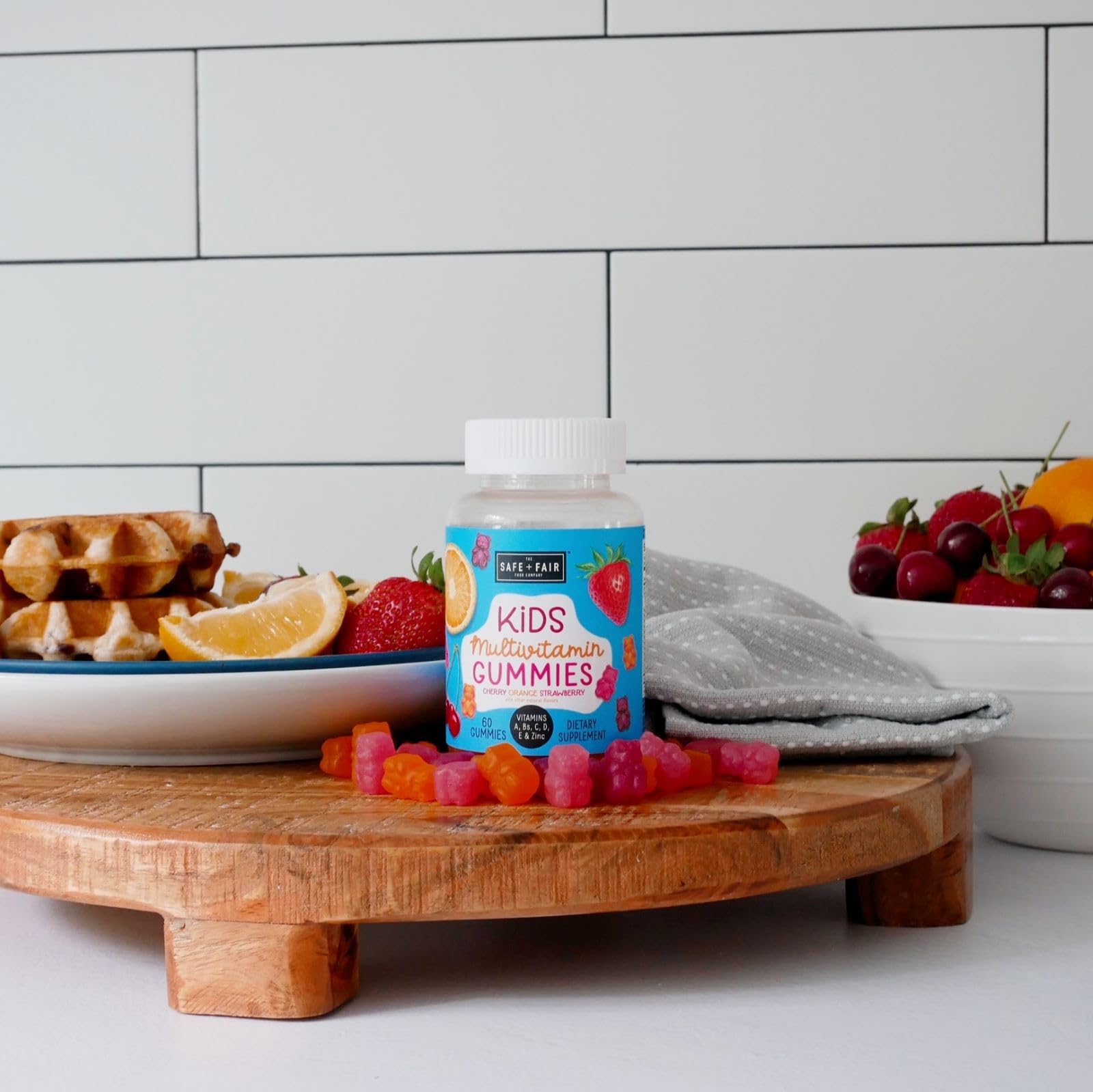 Gomitas multivitamínicas Safe + Fair servidas junto a frutas.