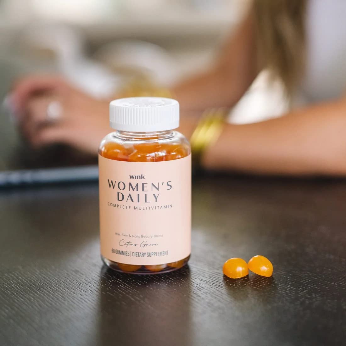 Mujer leyendo mientras usa gomitas multivitamínicas Wink Well