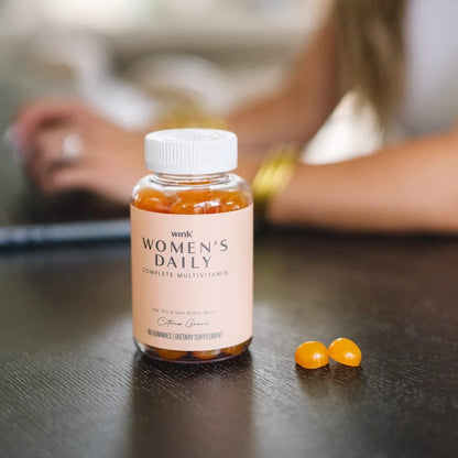 Mujer leyendo mientras usa gomitas multivitamínicas Wink Well