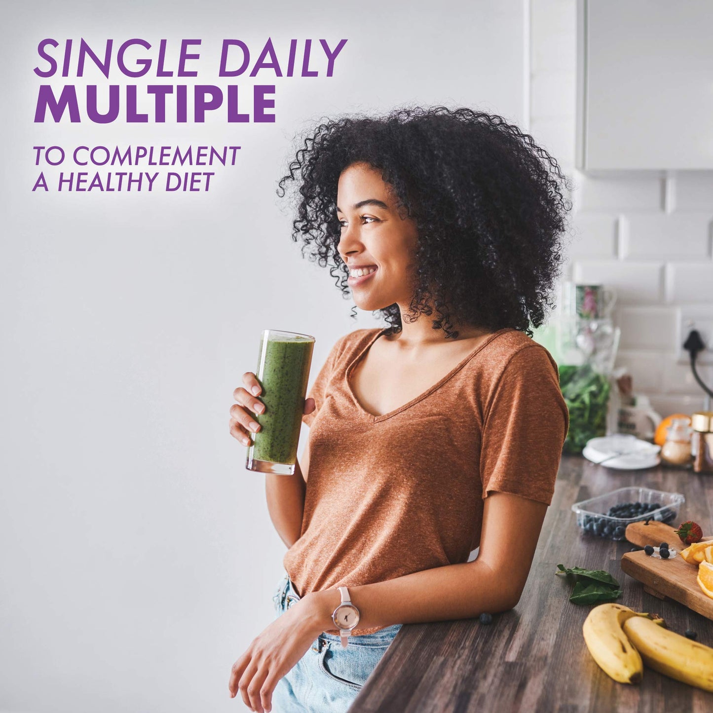 Mujer saludable con batido verde en la cocina.
