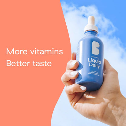 multivitamínico líquido Better Family en la mano bajo el cielo azul