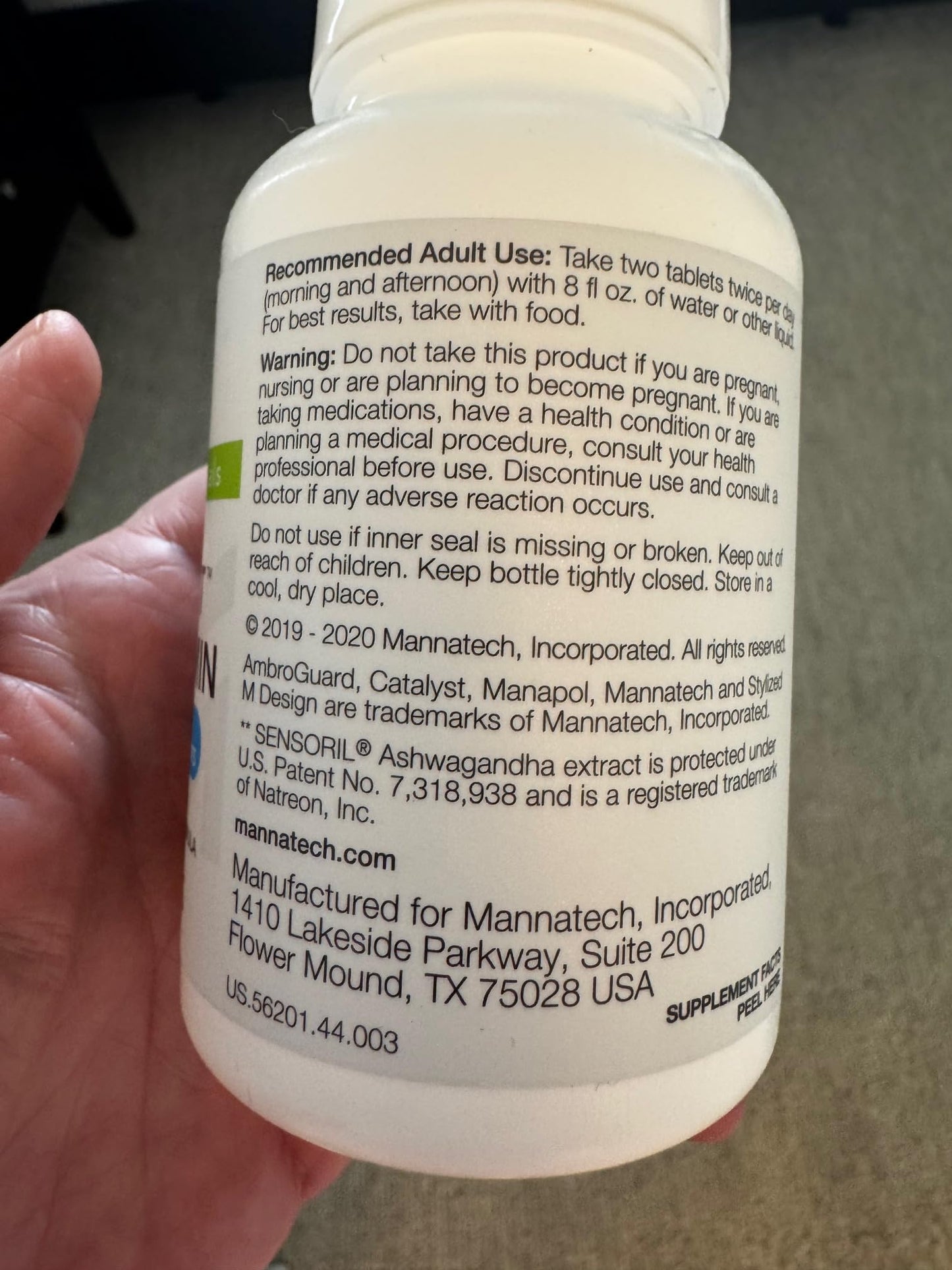 Persona sosteniendo botella de multivitaminas Catalyst
