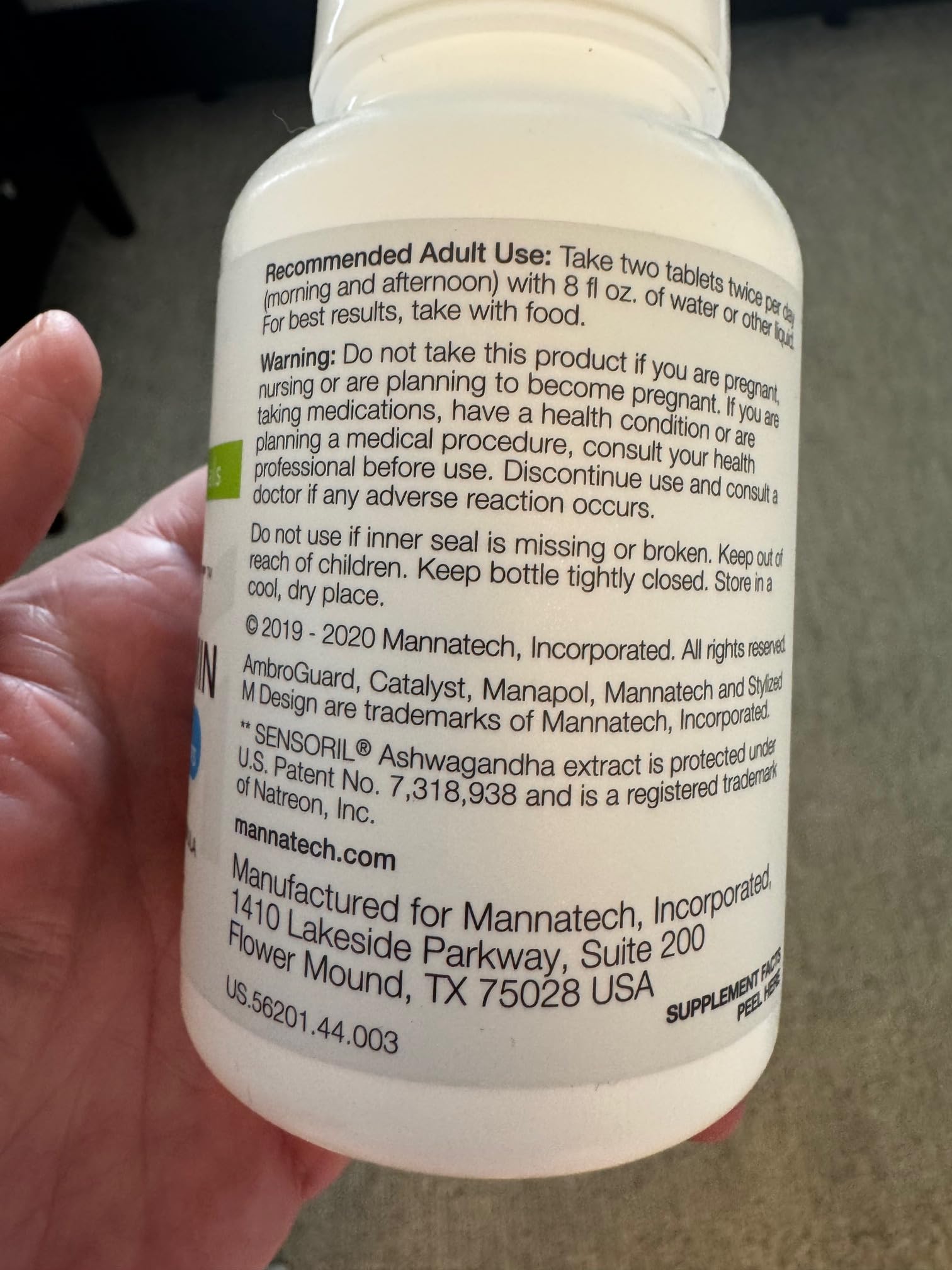 Persona sosteniendo botella de multivitaminas Catalyst