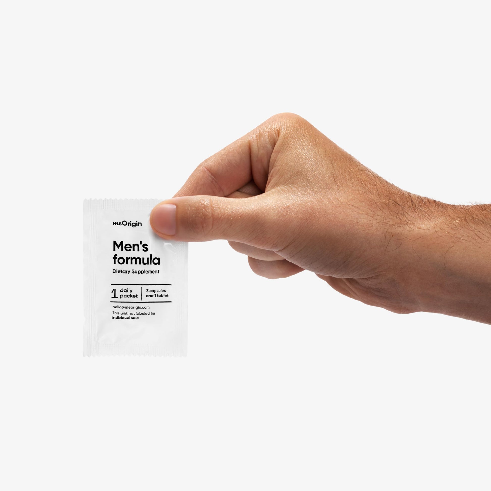 Suplemento meOrigin multivitamínico en mano