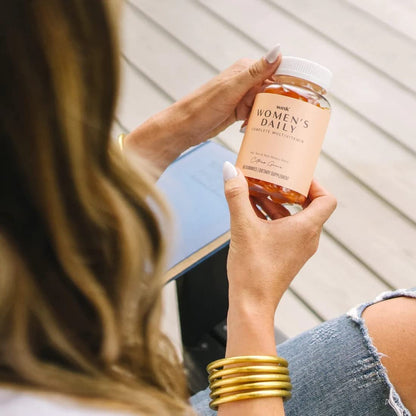 Suplemento multivitamínico para mujeres en mano - Wink Well