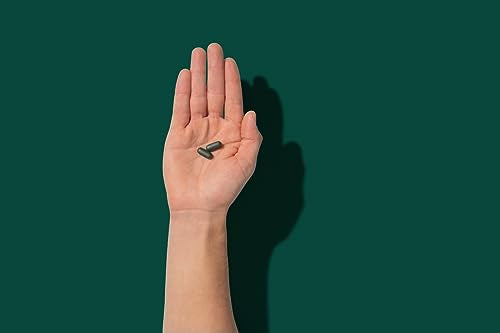 Tabletas multivitamínicas ROMAN para hombres en la palma de la mano.