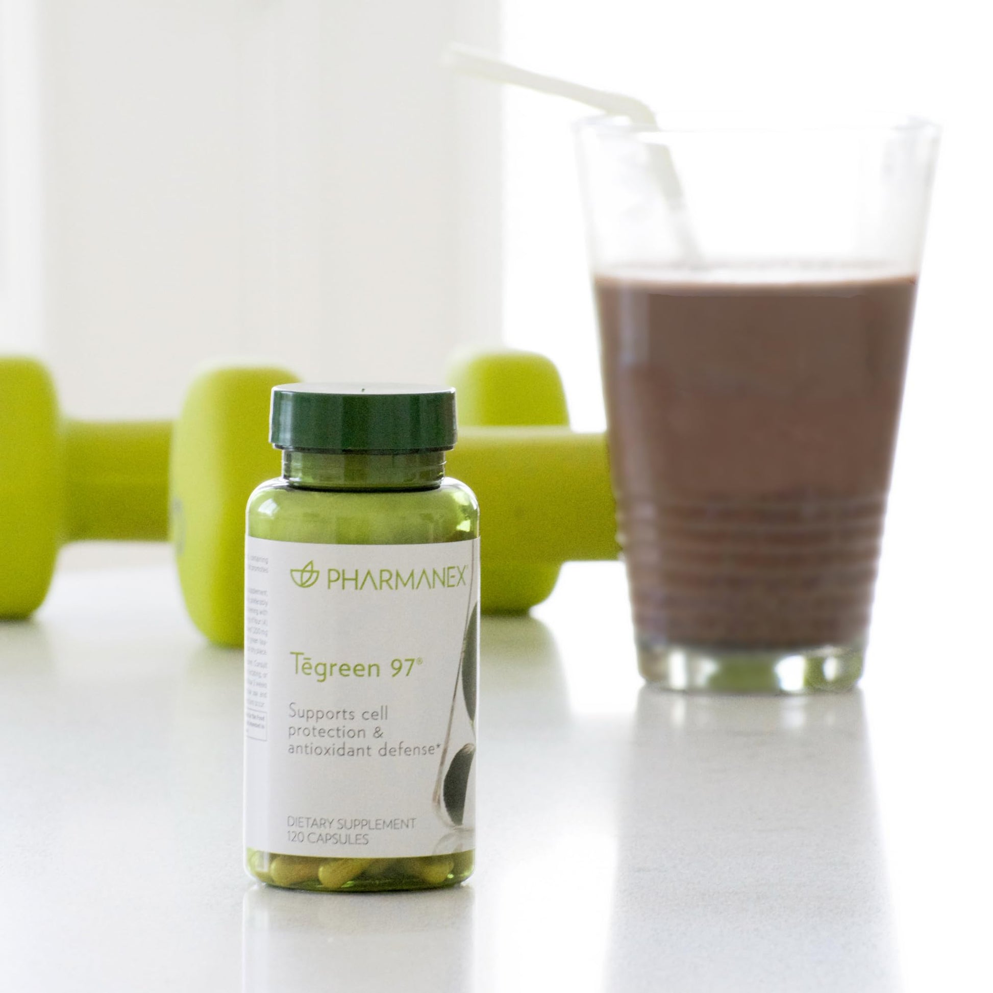 Tegreen 97 de Nu Skin junto a un batido y mancuernas