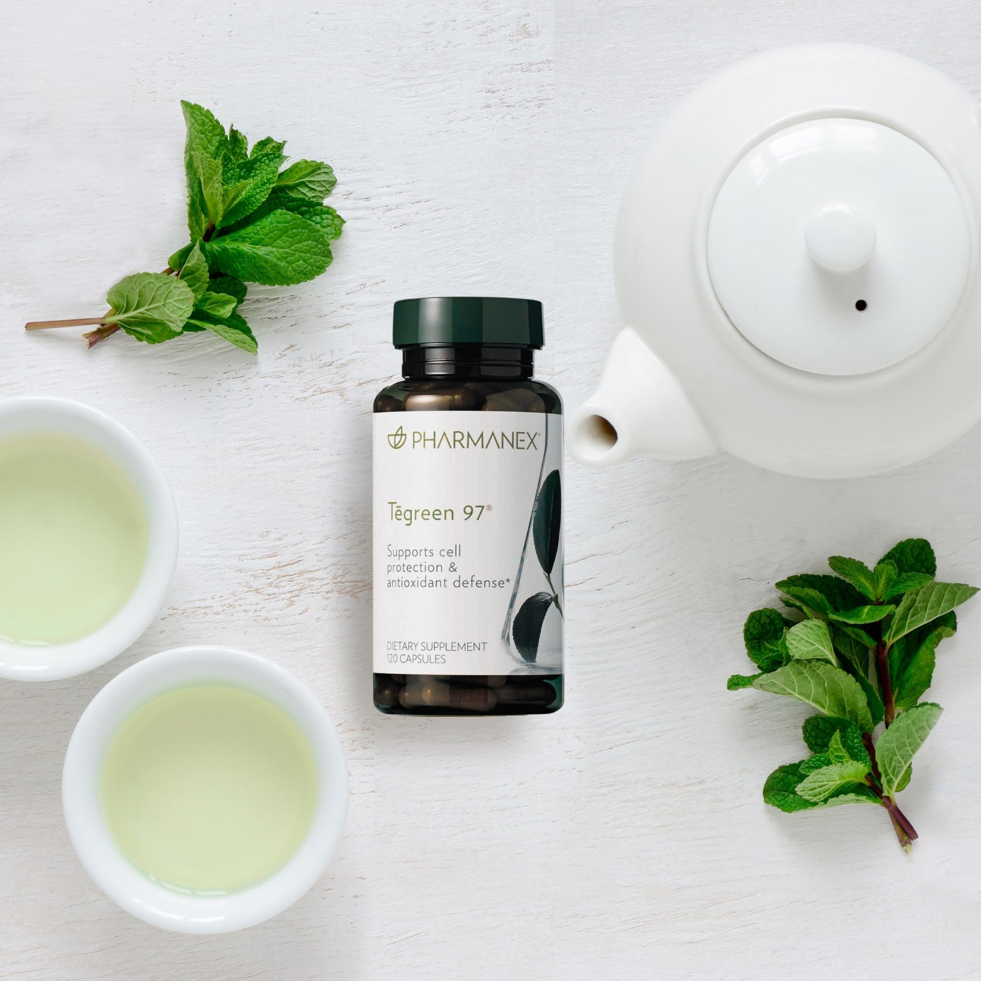 Tegreen 97 de Nu Skin con hojas y tazas de té