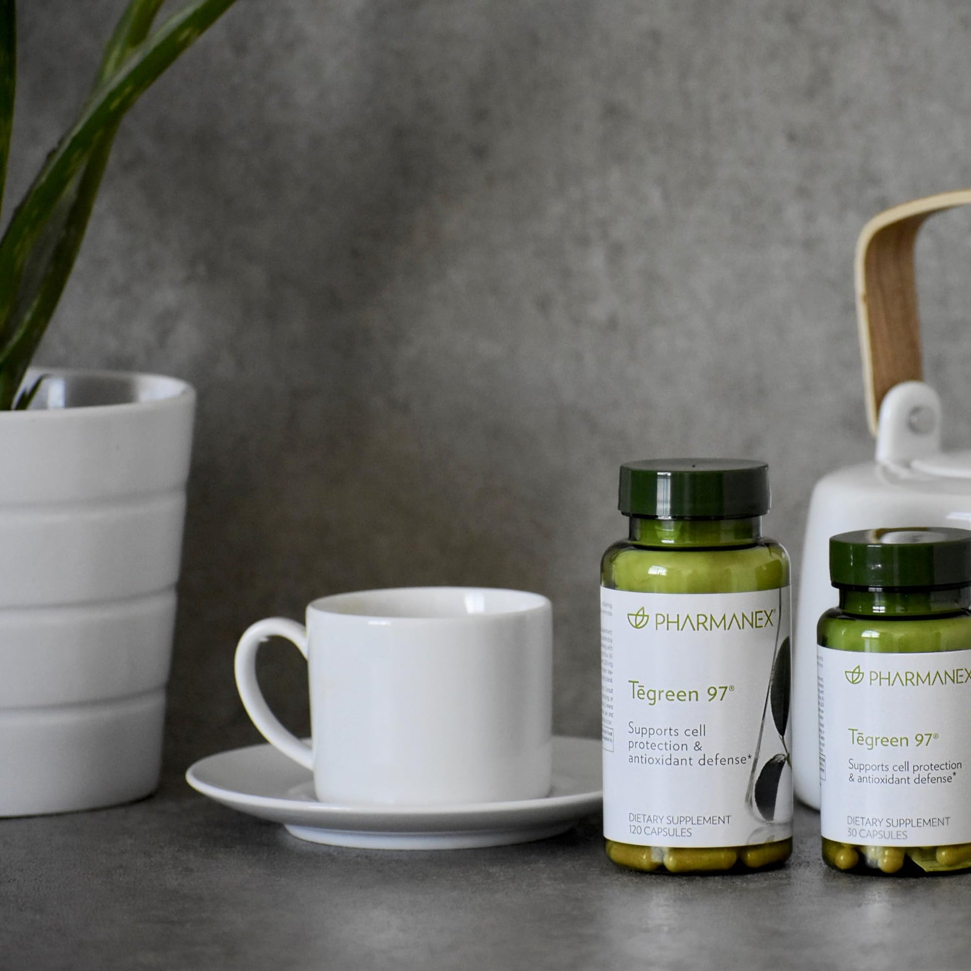 Tegreen 97 de Nu Skin en una mesa con taza y tetera