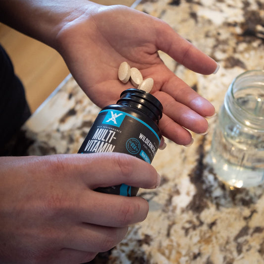 Tomando multivitamínico Wilderness Athlete con agua