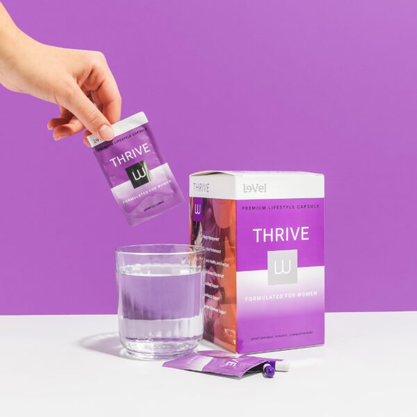 Cápsulas Le-Vel Thrive visibles y etiqueta de vitaminas para mujeres