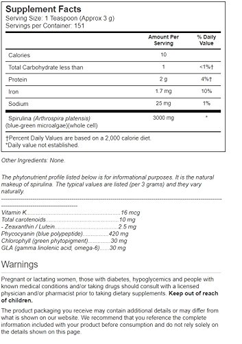 Cucharadita con polvo de spirulina Vitacost sobre fondo blanco