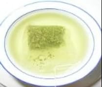 Bolsita de té verde Tai Chi abierta mostrando hojas frescas