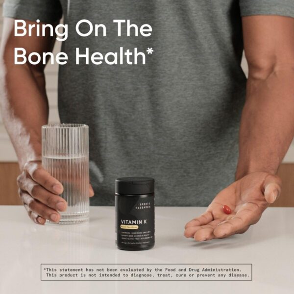 Cápsulas veganas Vitamina K Multi-Espectro Sports Research en mano