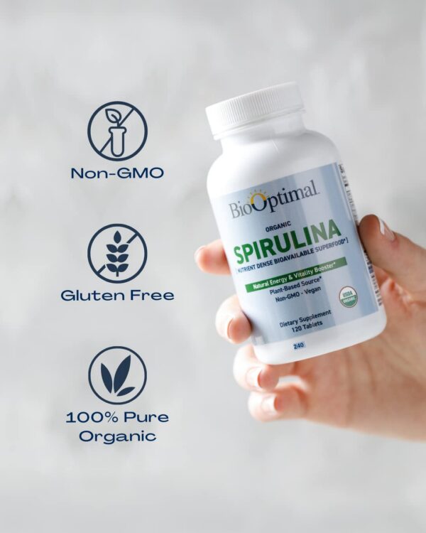 Tabletas espirulina BioOptimal en mano